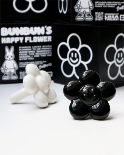 BUNBUN’S HAPPY FLOWER - collectible art toy sculpture. White and black flower-shaped figurines in front of a branded box.