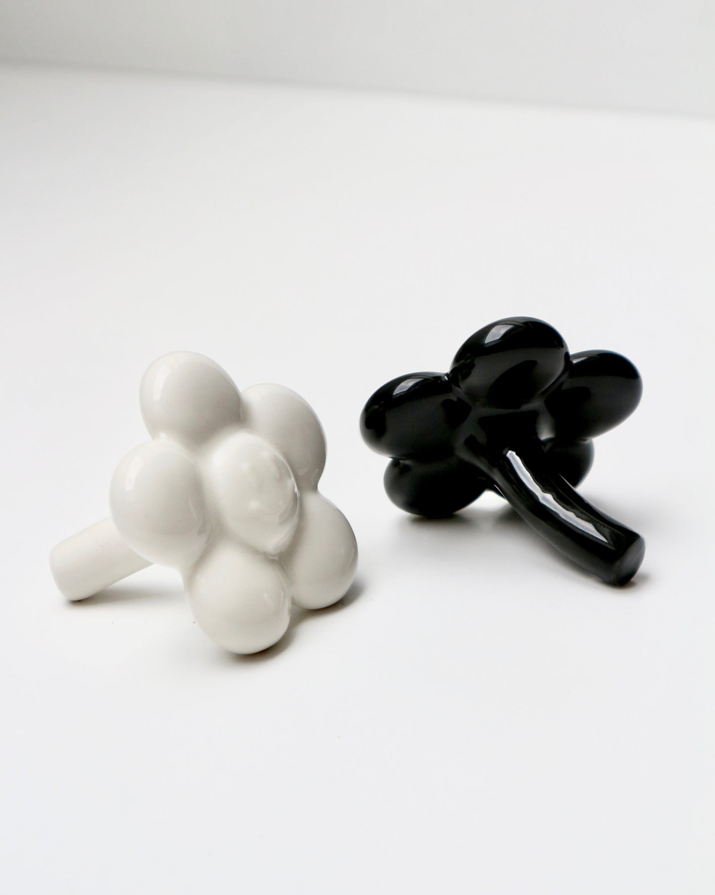 BUNBUN’S HAPPY FLOWER - collectible art toy sculpture. White and black flower-shaped figurines against a white background.