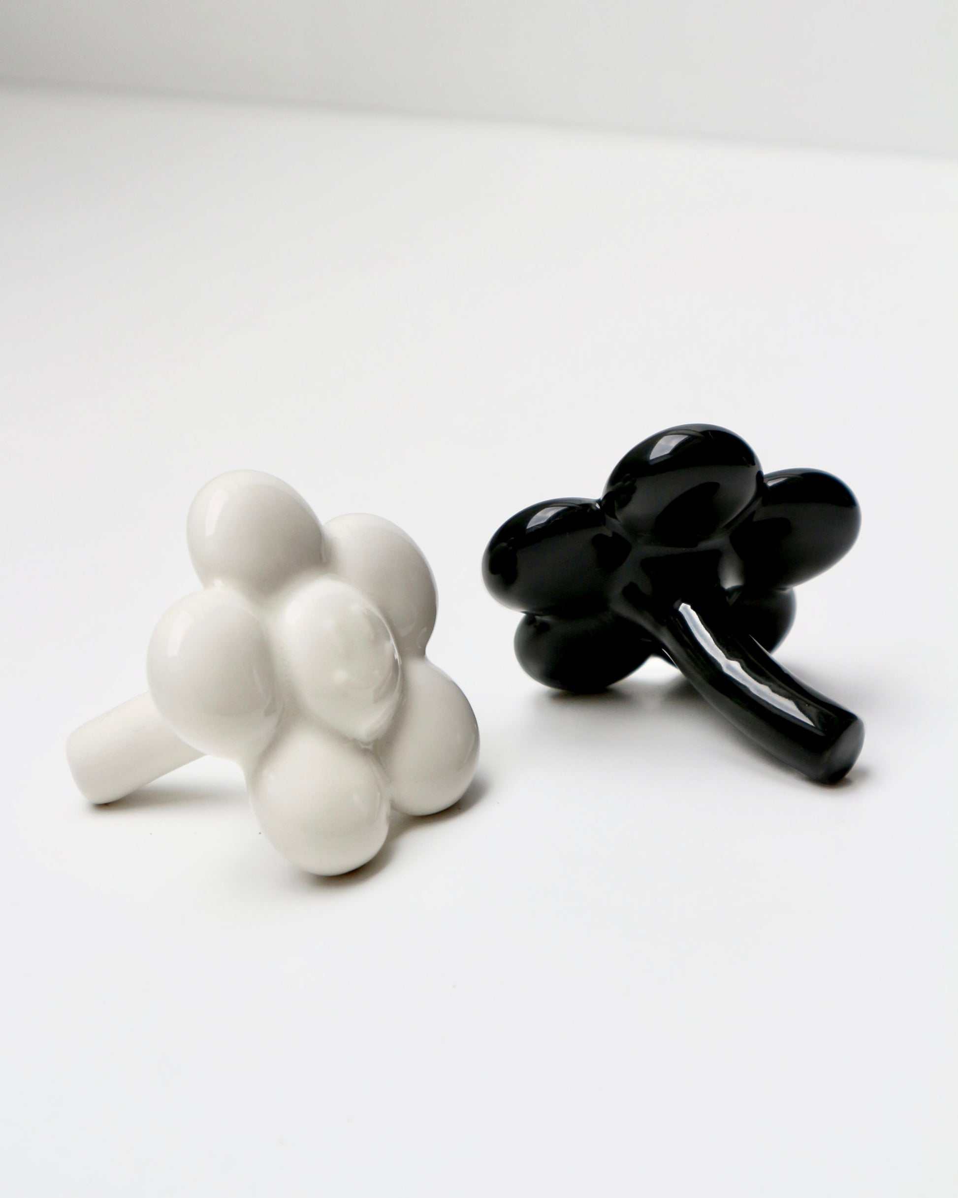 BUNBUN’S HAPPY FLOWER - collectible art toy sculpture. White and black flower-shaped figurines against a white background.