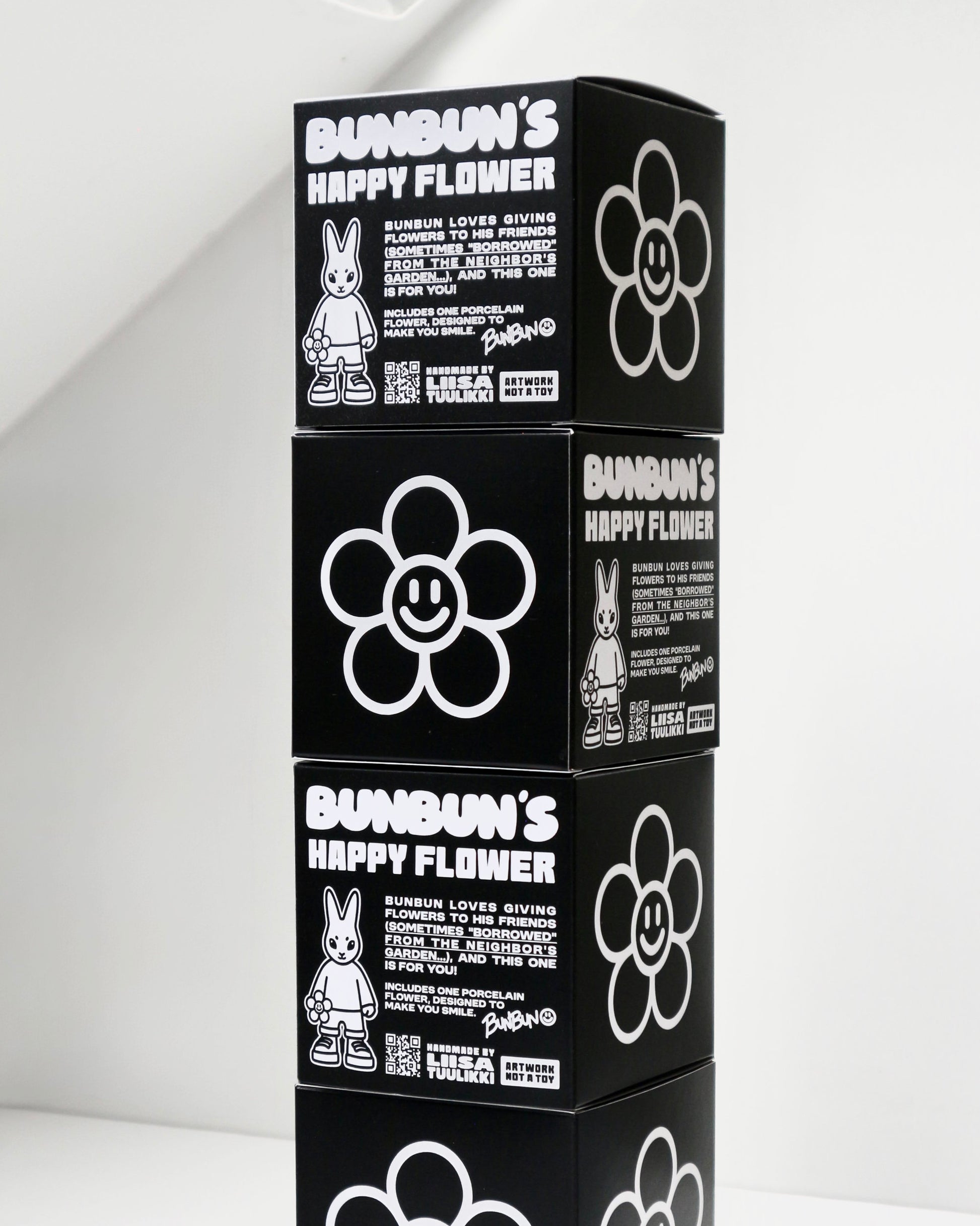 BUNBUN’S HAPPY FLOWER - collectible art toy sculpture. Stack of black boxes with 'Bundun's Happy Flower' branding on a white background.