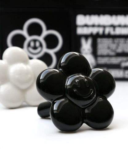 BUNBUN’S HAPPY FLOWER - collectible art toy sculpture. White and black flower-shaped figurines in front of a branded box.