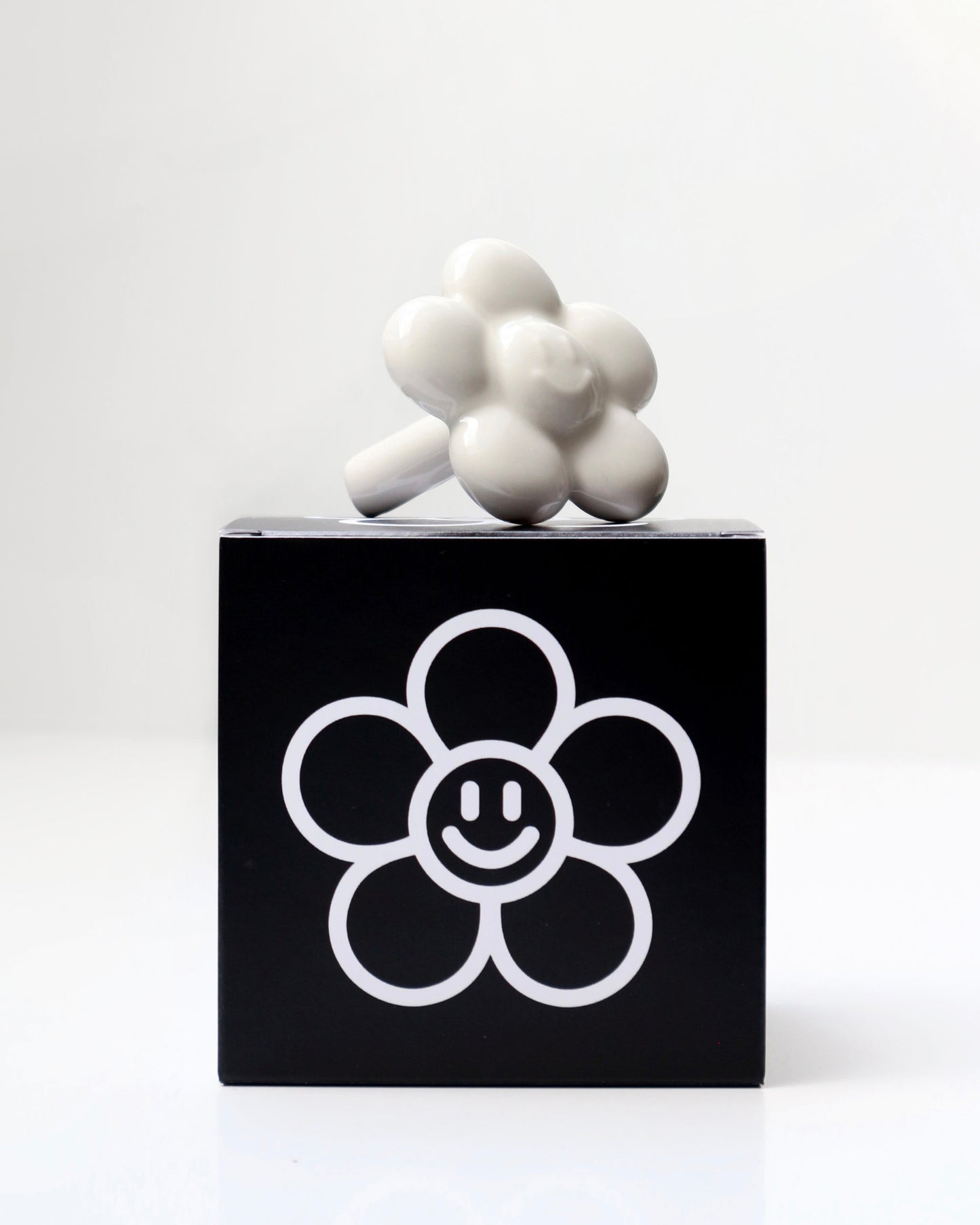 BUNBUN’S HAPPY FLOWER - collectible art toy sculpture. White flower-shaped figurine on top of a branded box.